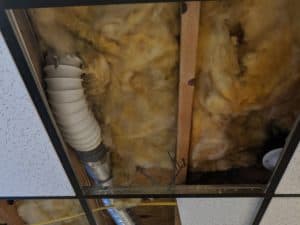 Picture of a combination of vinyl and semi-rigid ducting used for dryer venting in a ceiling. This is a code violation from a dryer vent repair job in Frederick County.