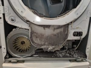 Picture of frontloaded dryer with door removed. Large a]mount of lint accumulated. Dryer vent cleaning job in Clarksburg, MD.