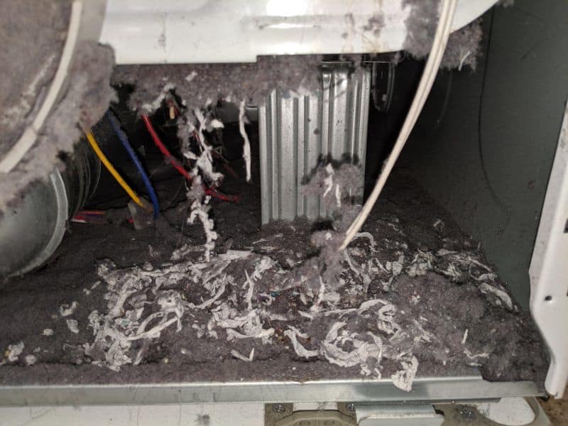 Picture of significant lint buildup beneath a dryer heater. This is a fire hazard. This was from a dryer vent cleaning job in Clarksburg, MD.