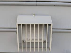 Picture of a beige Defender brand bird guard on a dryer vent. They are designed to let lint pass through but keep birds out. This is from a bird guard installation job in Charles Tow,n WV.