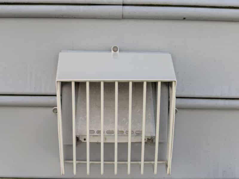 Picture of a beige Defender brand bird guard on a dryer vent. They are designed to let lint pass through but keep birds out. This is from a bird guard installation job in Charles Tow,n WV.