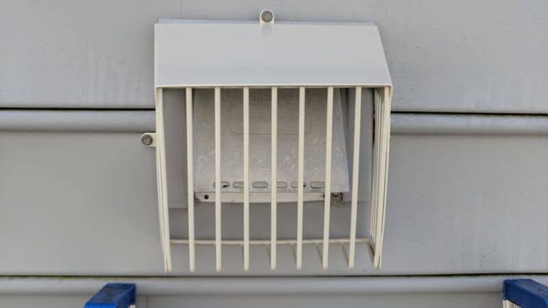 Picture of a beige Defender brand bird guard on a dryer vent. They are designed to let lint pass through but keep birds out. This is from a bird guard installation job in Clarksburg, MD.