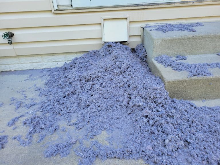 Pile of lint outside under dryer vent after dryer vent cleaning service