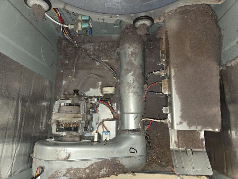 Picture of inside of dryer with drum removed. Dryer is very dirty with lint. This is picture before dryer cleaning service