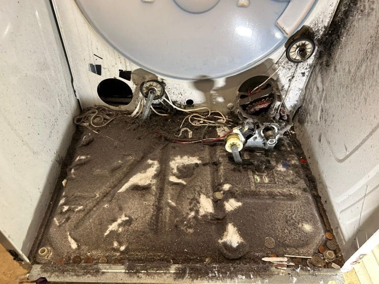 Picture of dryer with drum removed. Dryer is dirty and has bad drum rollers and pulley tensioner. Needs dryer repair and dryer cleaning services.